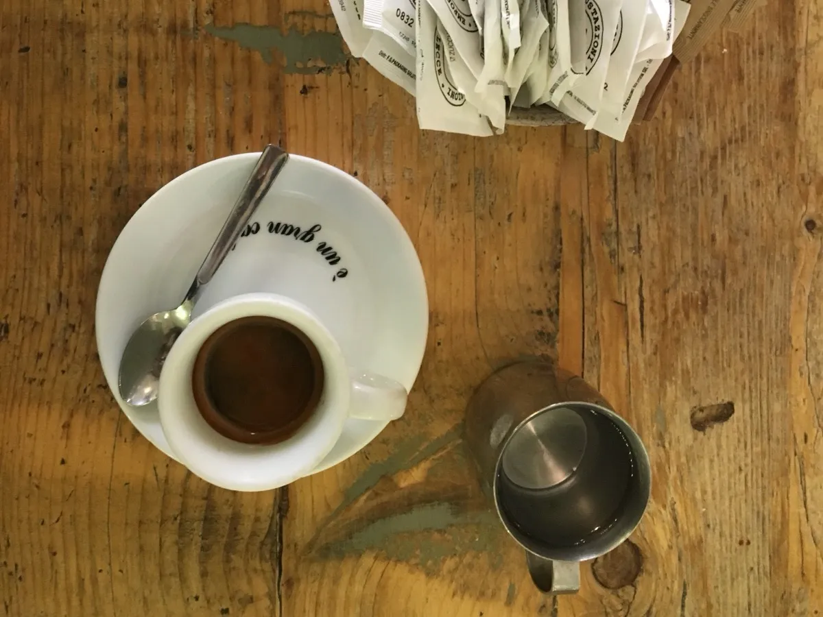 Espresso servi en tasse sur table en bois avec sucres et pot à lait