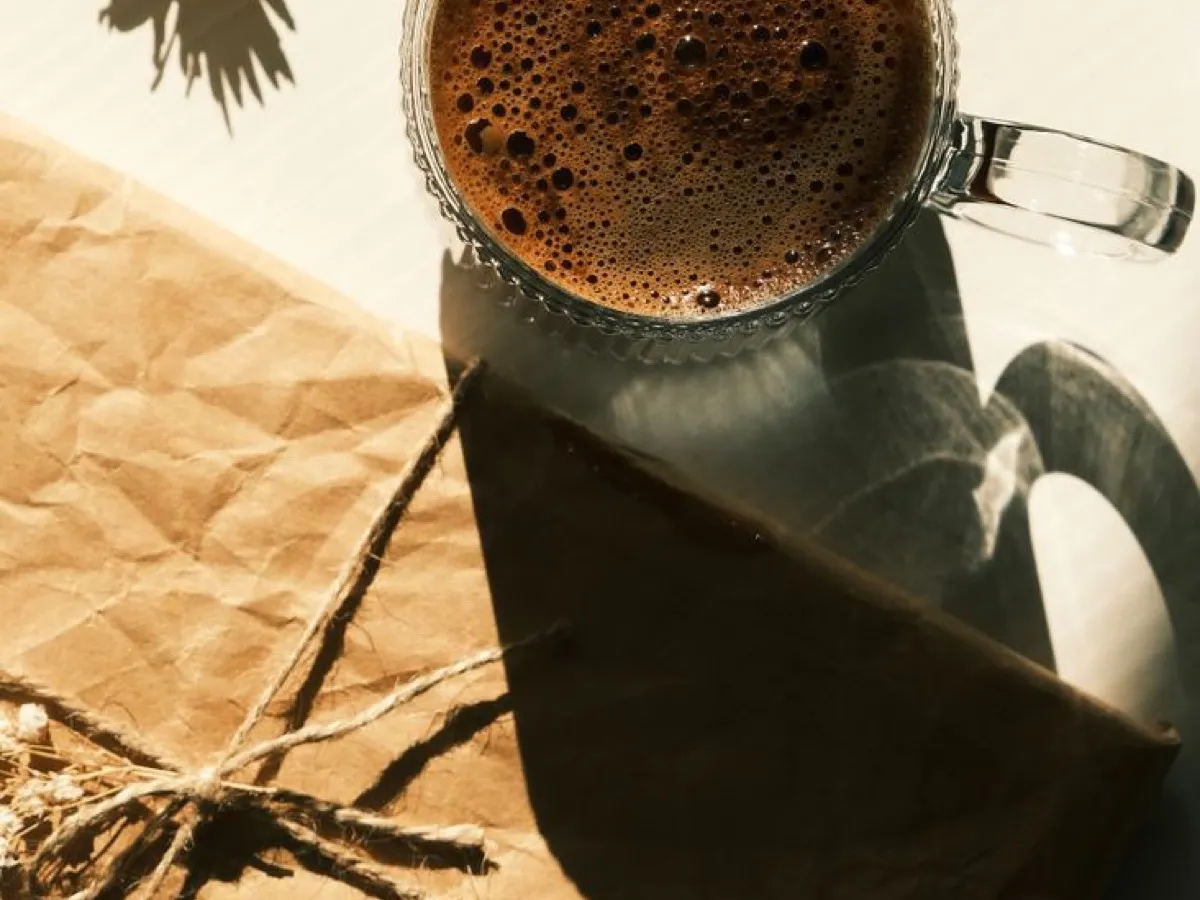 Mug de café posé sur un paquet cadeau en papier kraft, idée de cadeau pour un amateur de café