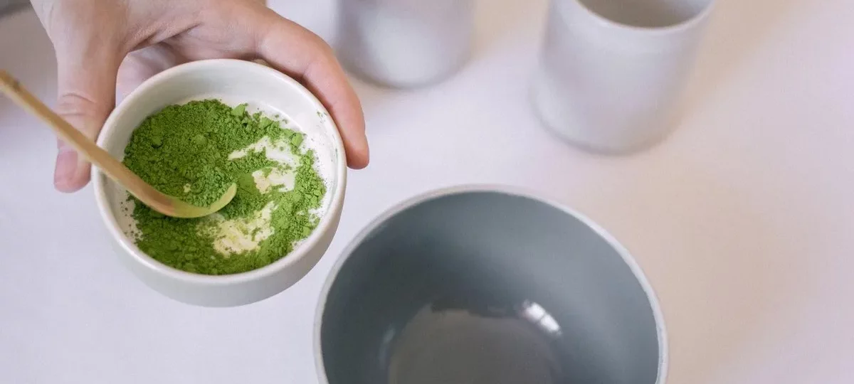 Bol de poudre de thé matcha vert vif et cuillère en bambou, prêt pour la préparation