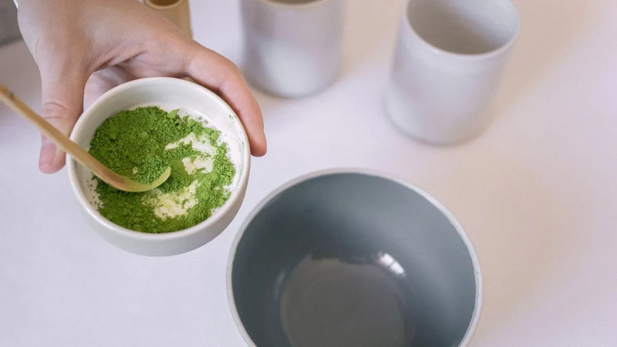 Bol de poudre de thé matcha vert vif et cuillère en bambou, prêt pour la préparation