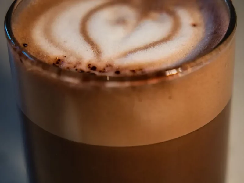 Café macchiato en petit verre, espresso taché d'une touche de mousse de lait en forme de cœur