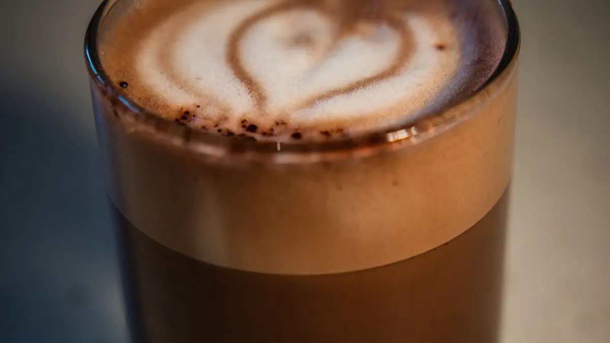 Café macchiato en petit verre, espresso taché d'une touche de mousse de lait en forme de cœur