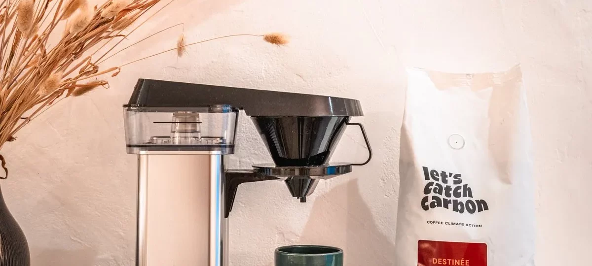 Cafetière filtre électrique Moccamaster en inox à côté d'un sachet de café let's catch carbon