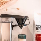 Cafetière filtre électrique Moccamaster en inox à côté d'un sachet de café let's catch carbon
