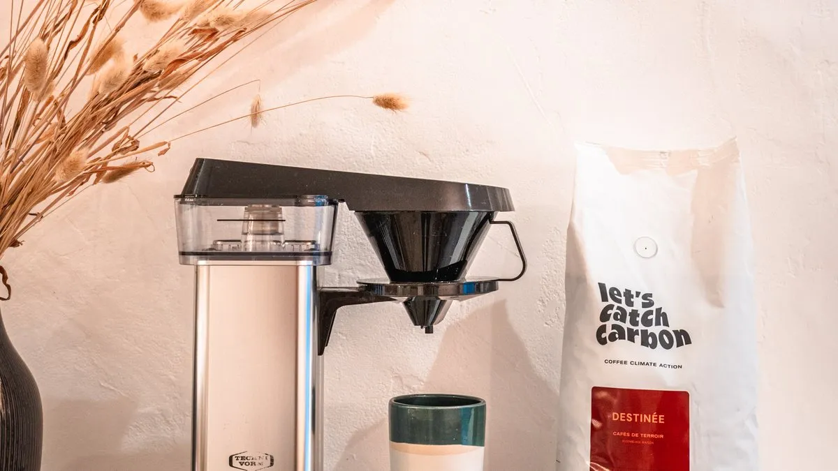 Cafetière filtre électrique Moccamaster en inox à côté d'un sachet de café let's catch carbon