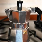 Cafetière italienne moka en aluminium posée sur une gazinière, prête à préparer le café