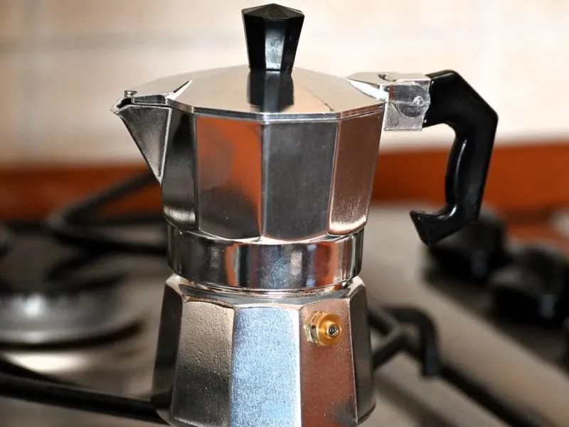 Cafetière italienne moka en aluminium posée sur une gazinière, prête à préparer le café