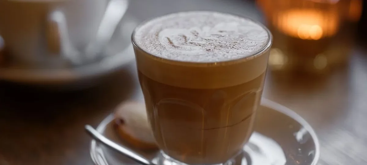 Cortado servi dans un petit verre sur soucoupe, expresso coupé d'un peu de lait chaud