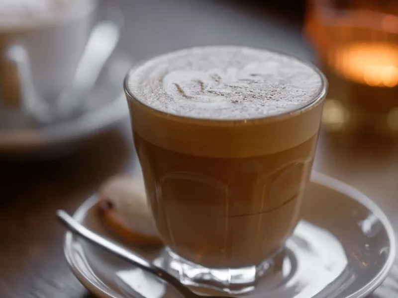 Cortado servi dans un petit verre sur soucoupe, expresso coupé d'un peu de lait chaud
