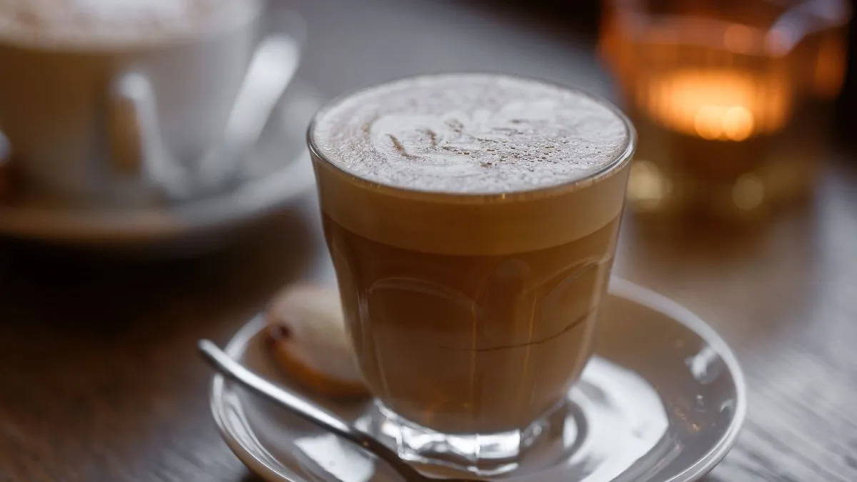 Cortado servi dans un petit verre sur soucoupe, expresso coupé d'un peu de lait chaud