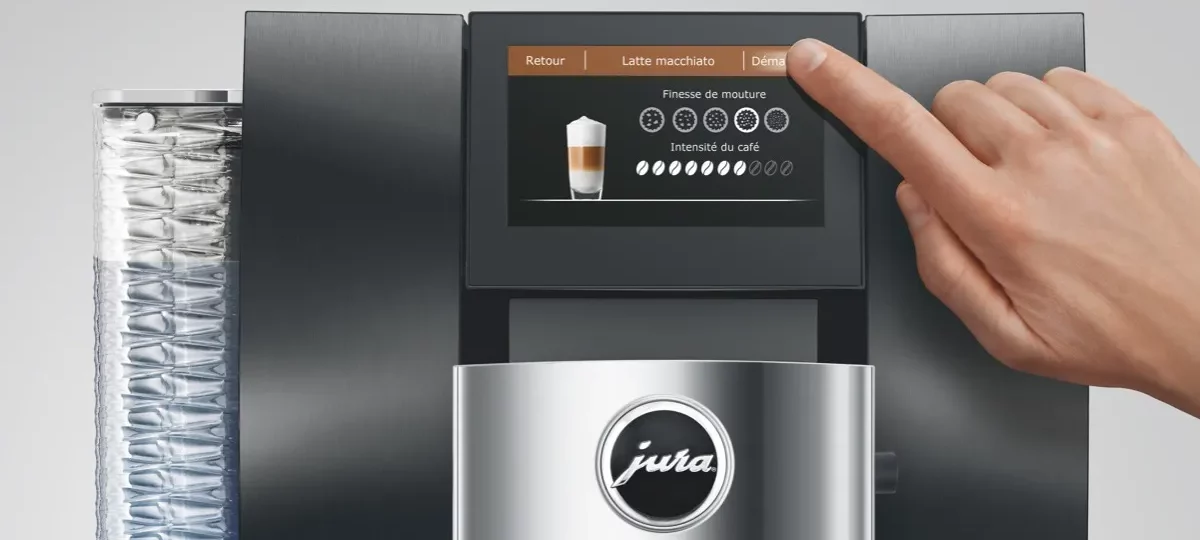 Doigt réglant la finesse de mouture et l'intensité du café sur l'écran tactile d'une machine à café Jura Z10