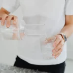 Eau versée d'une carafe dans un verre, l'eau filtrée qui limite le calcaire dans la machine