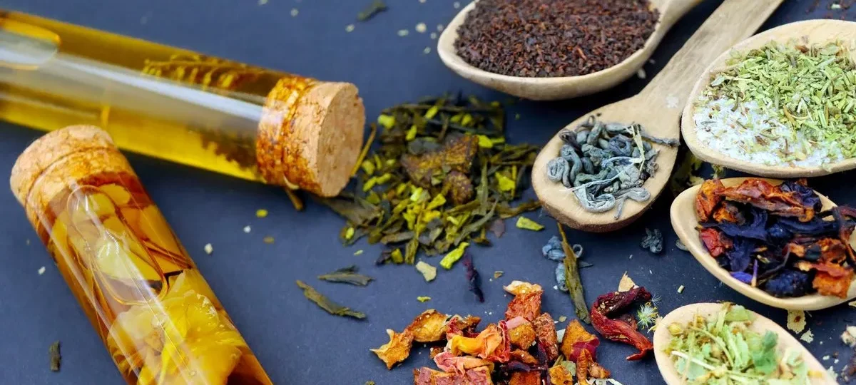 Feuilles de thé et plantes à infusion séchées dans des cuillères en bois
