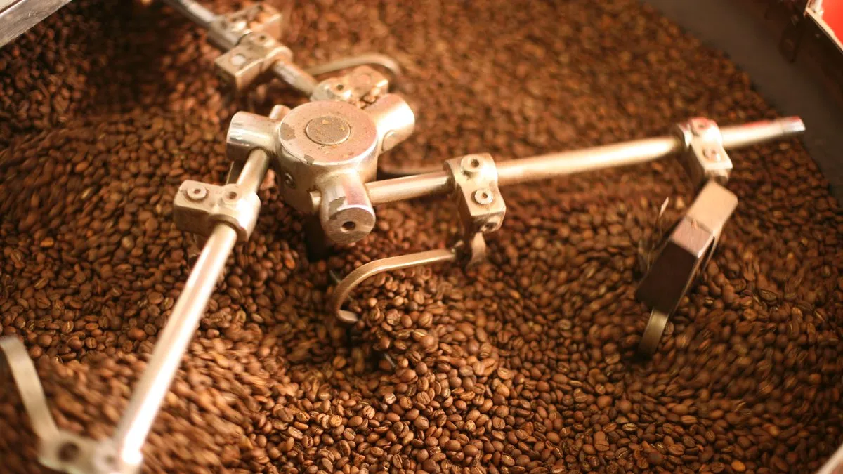 Grains de café brassés dans le bac de refroidissement d'un torréfacteur après la torréfaction