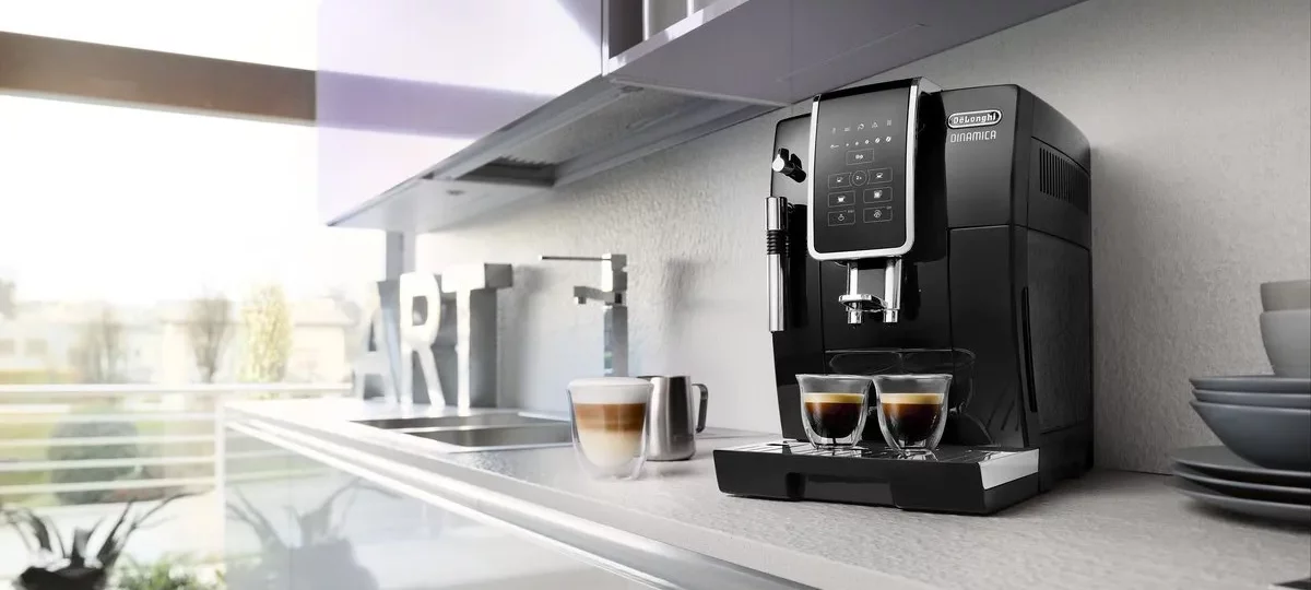 Machine à café à grains De'Longhi Dinamica noire dans une cuisine moderne, deux tasses servies