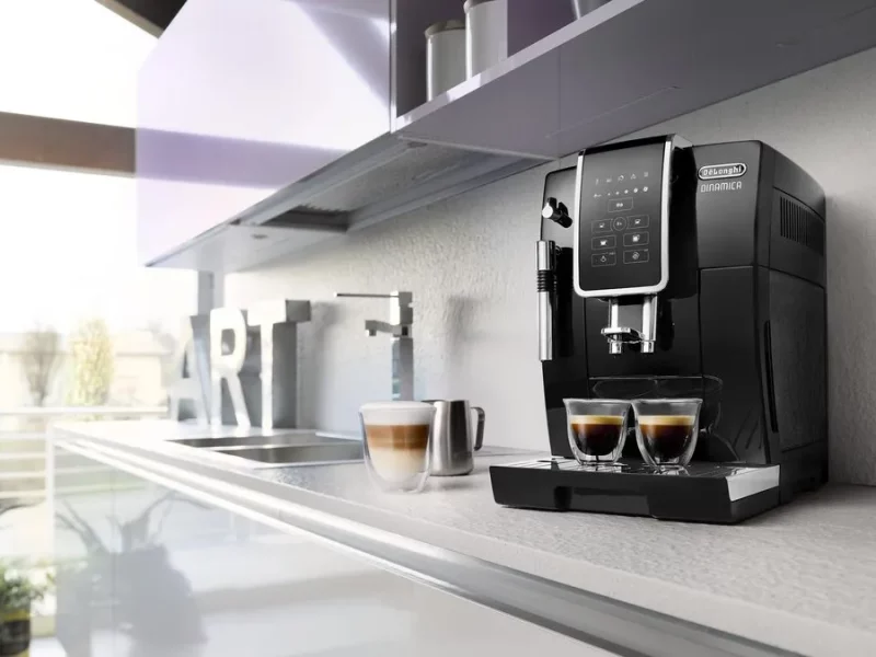 Machine à café à grains De'Longhi Dinamica noire dans une cuisine moderne, deux tasses servies