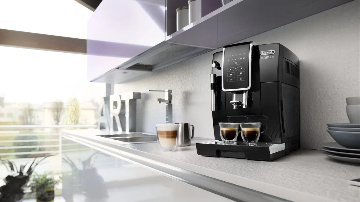Machine à café à grains De'Longhi Dinamica noire dans une cuisine moderne, deux tasses servies
