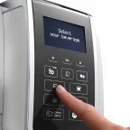 Doigt sélectionnant une boisson sur le panneau de commande d'une machine à grains De'Longhi