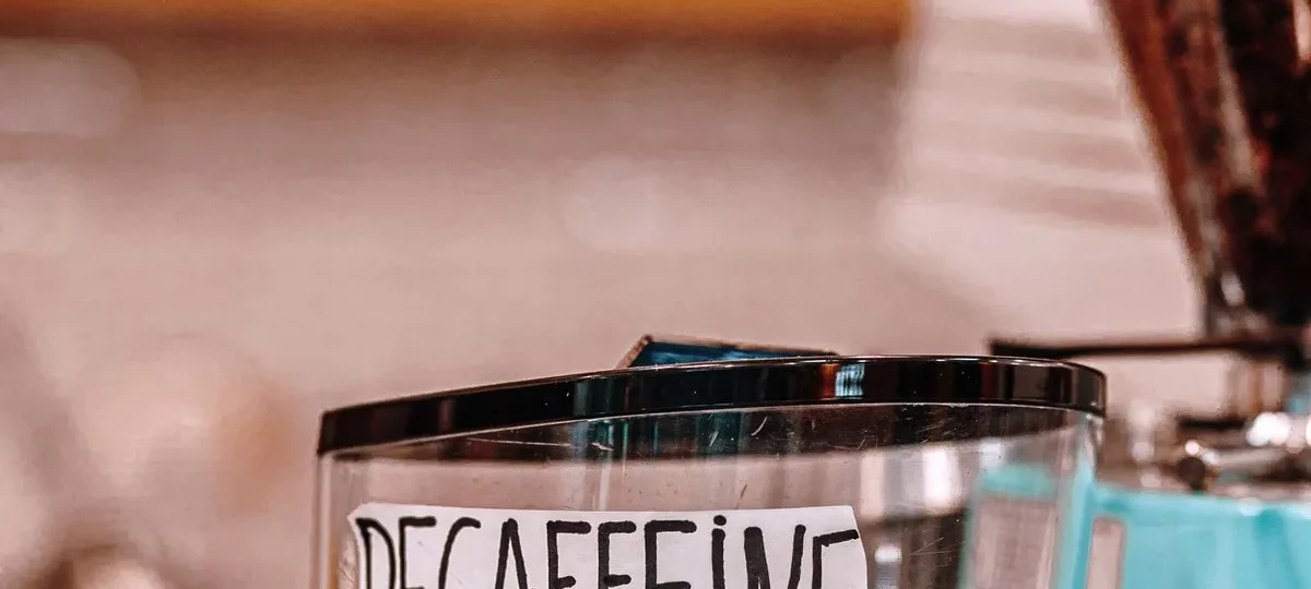 Moulin à café dont la trémie de grains porte l'étiquette « décaféiné »