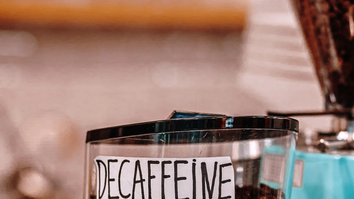 Moulin à café dont la trémie de grains porte l'étiquette « décaféiné »