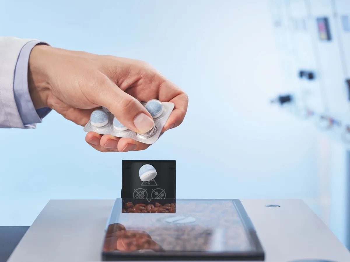 Pastille de nettoyage insérée dans une machine à café automatique pour nettoyer le circuit café