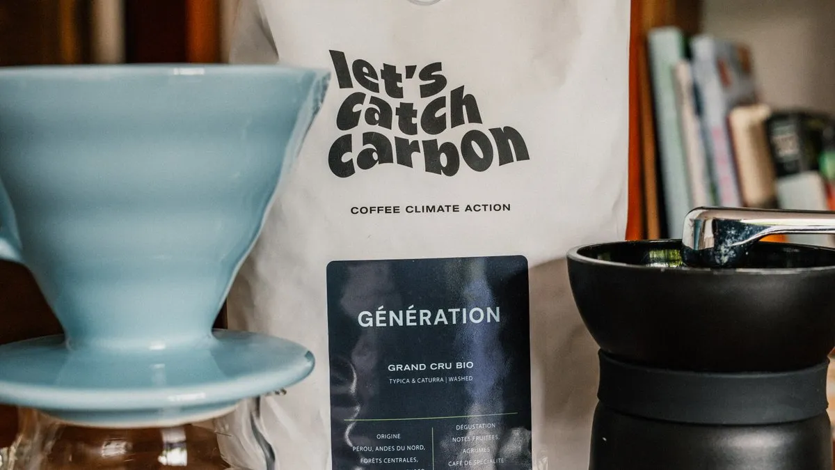 Sachet de café en grains bio let's catch carbon Génération à côté d'un dripper et d'un moulin à café manuel